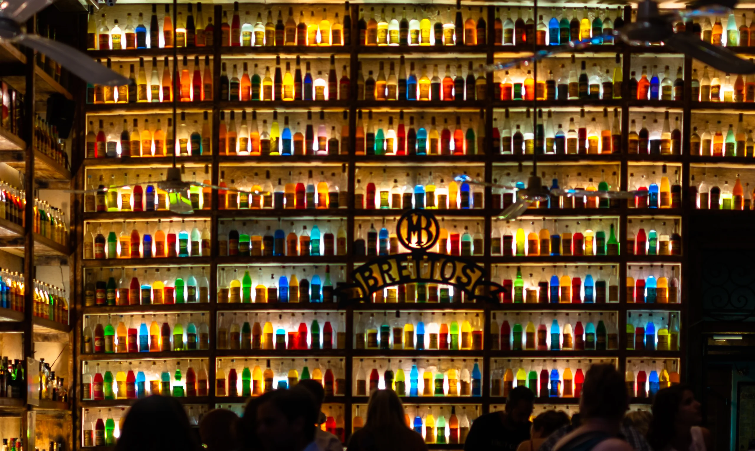Colorful shiny bottles on shelves in a bar in Athens, Greece.
