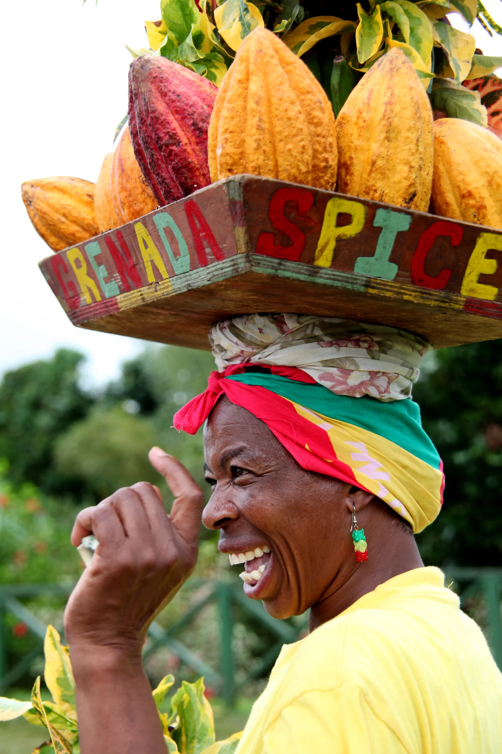 Grenada woman holding nutmeg spices on her head.