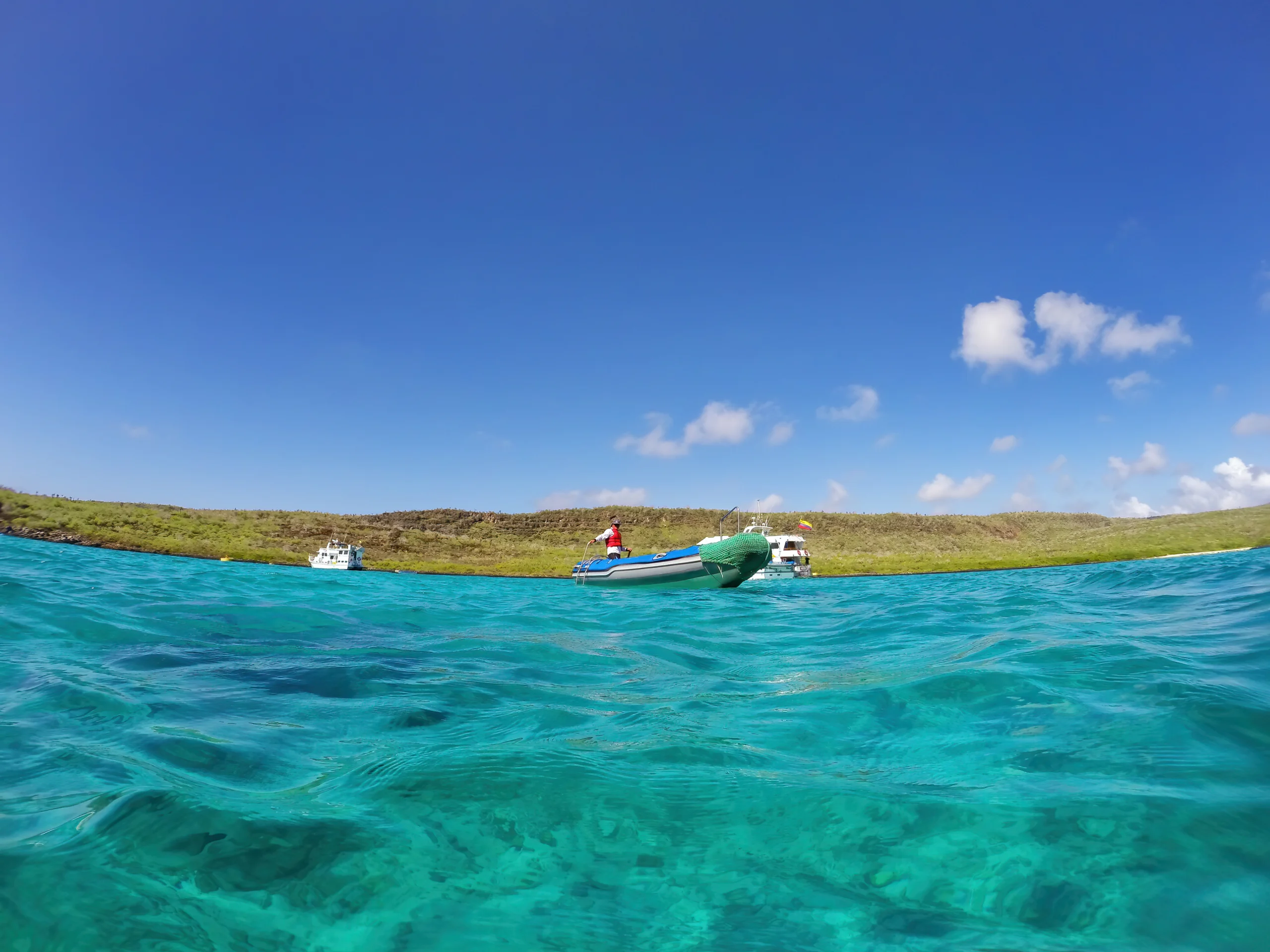Tourist boats anchored near Santa Fe Island, Galapagos National Park, Ecuador.