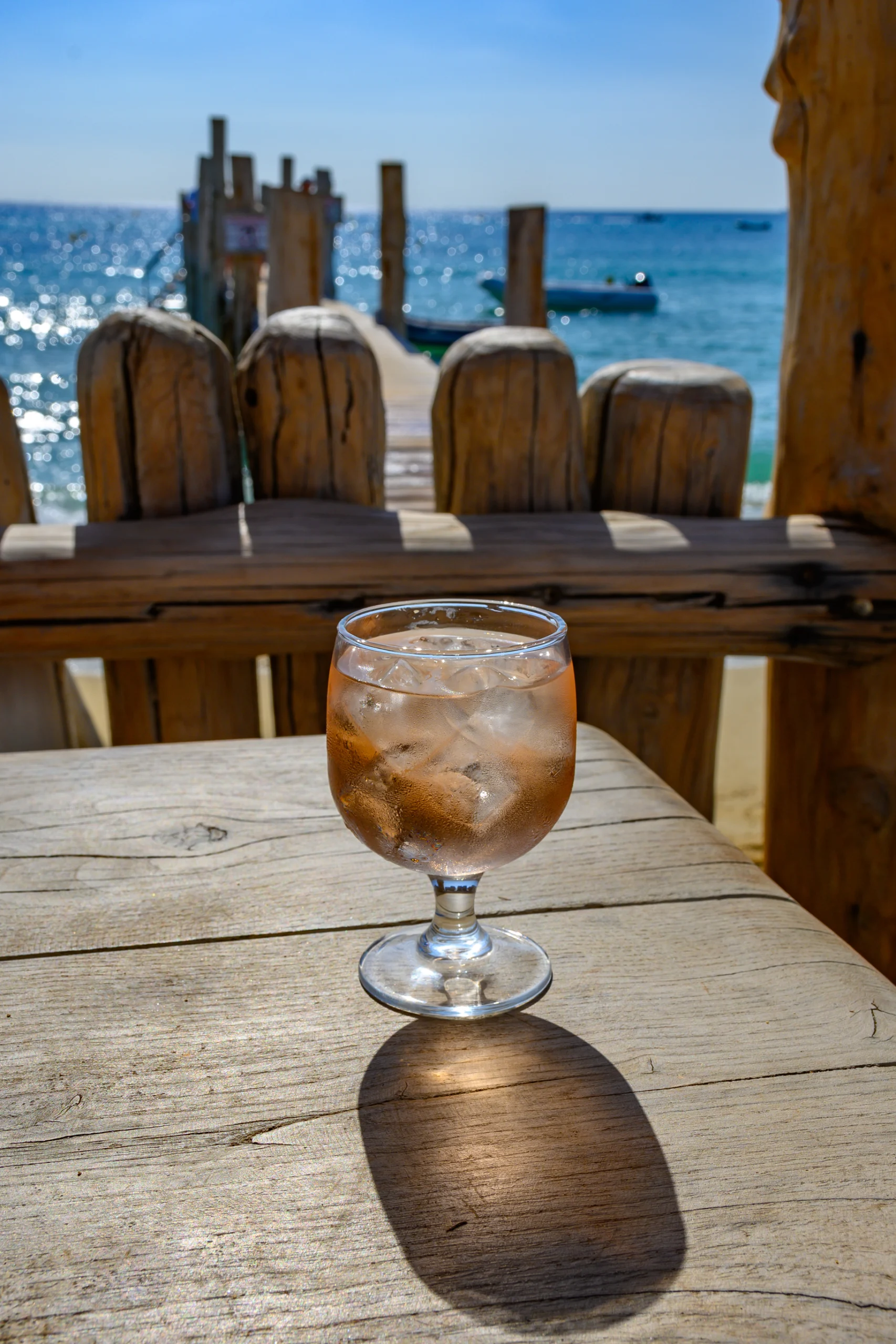 glass of rose wine with ice cubes on bar terrace.
