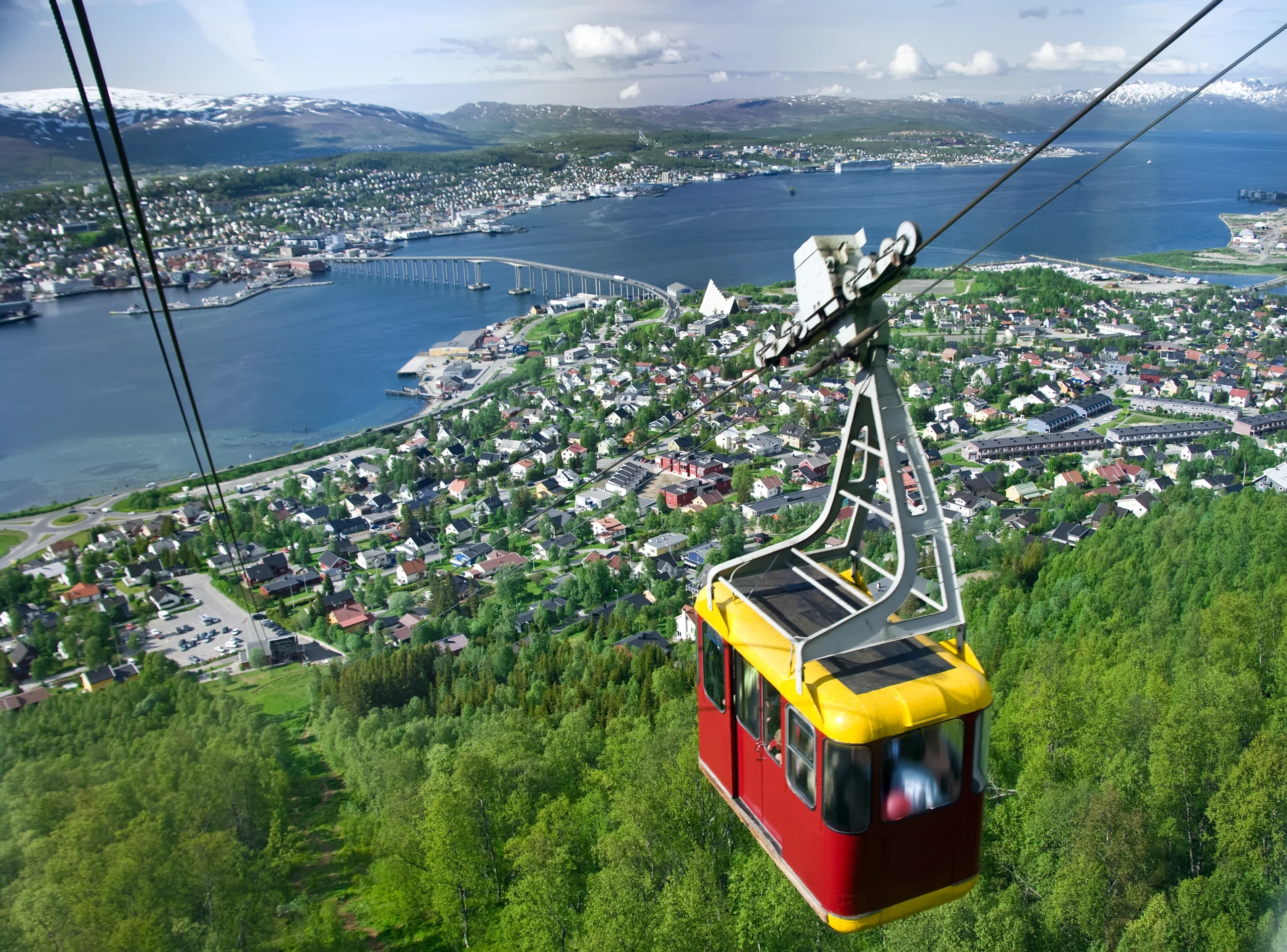 A cable car going up with Tromso panorama in the background.