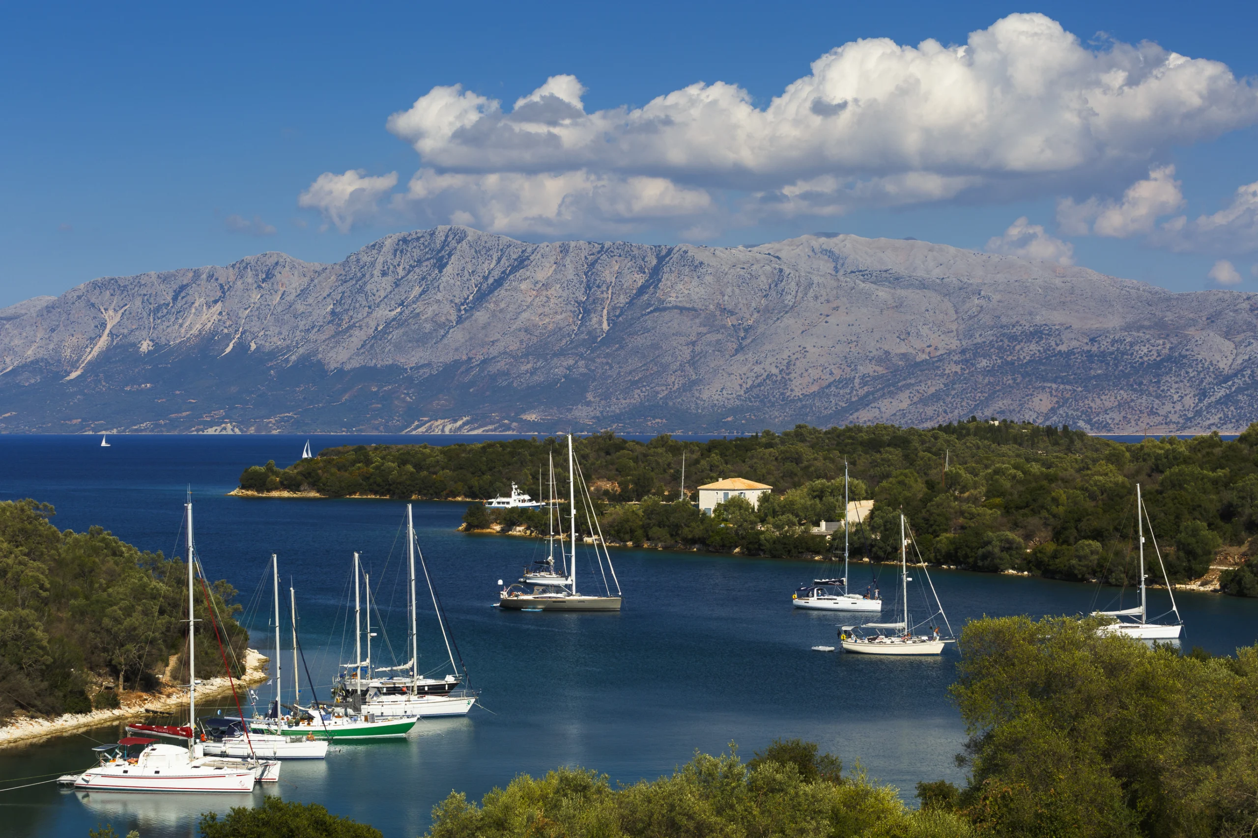 Sailboats in one of numerous small bays of Meganisi island, Greece.
