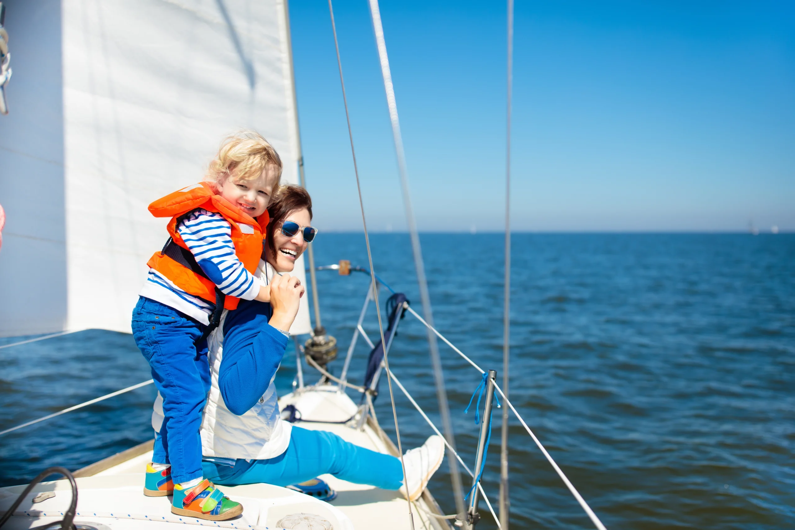 Mother and child on sea sail yacht.