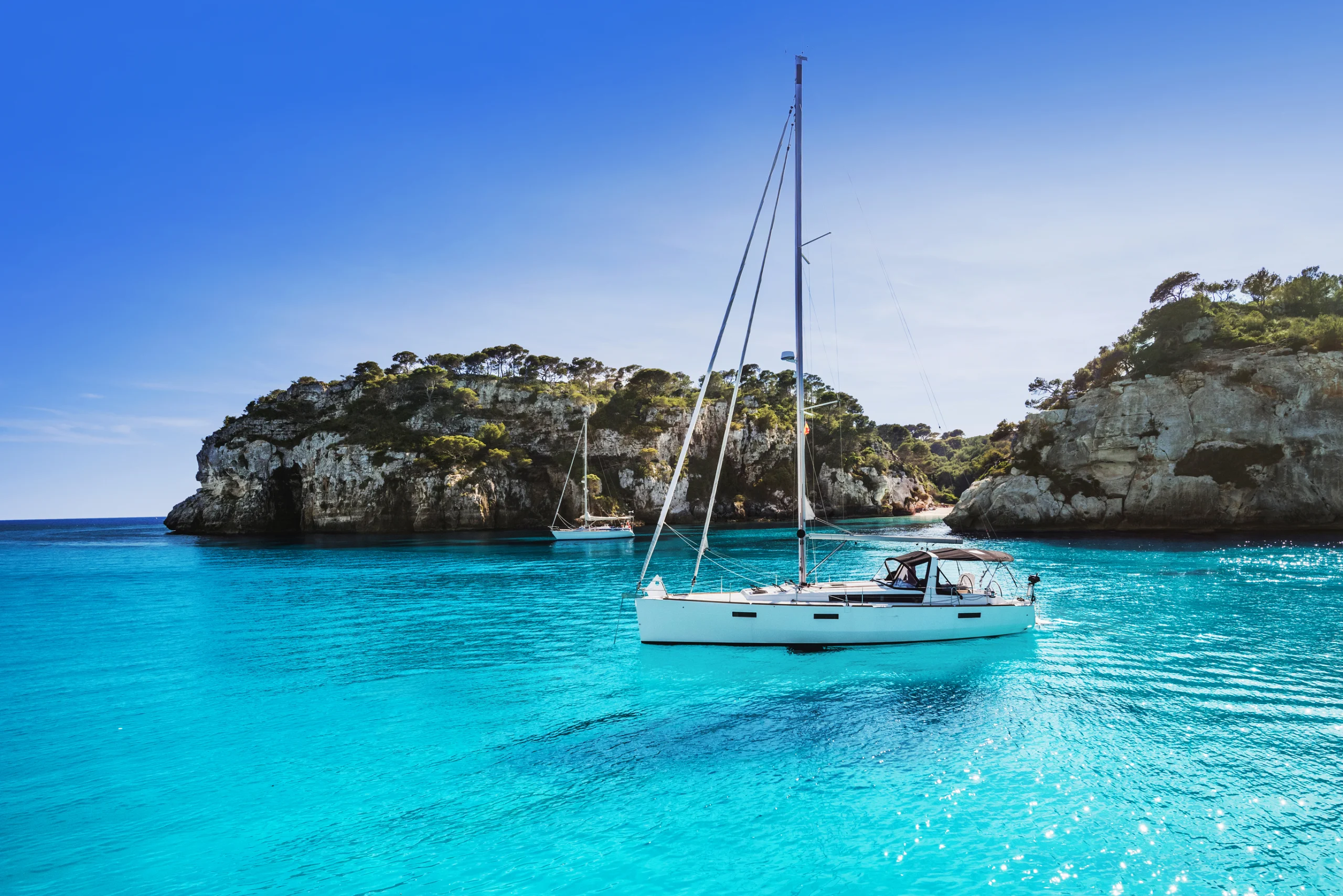 Beautiful beach with sailing boat yacht, Cala Macarelleta, Menorca island, Spain.