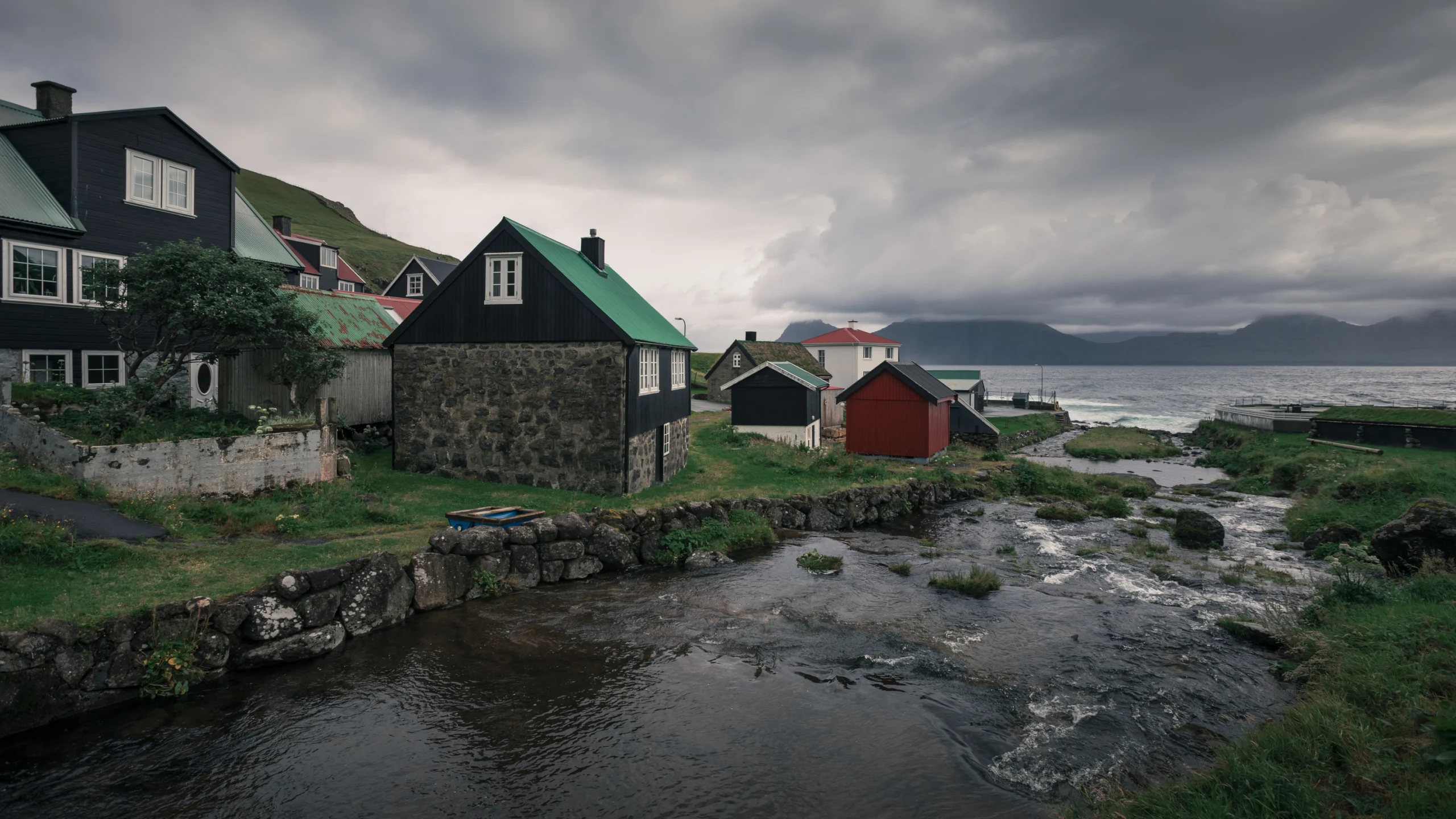 Houses by the river in the village of Gjogv, Faroe Islands.