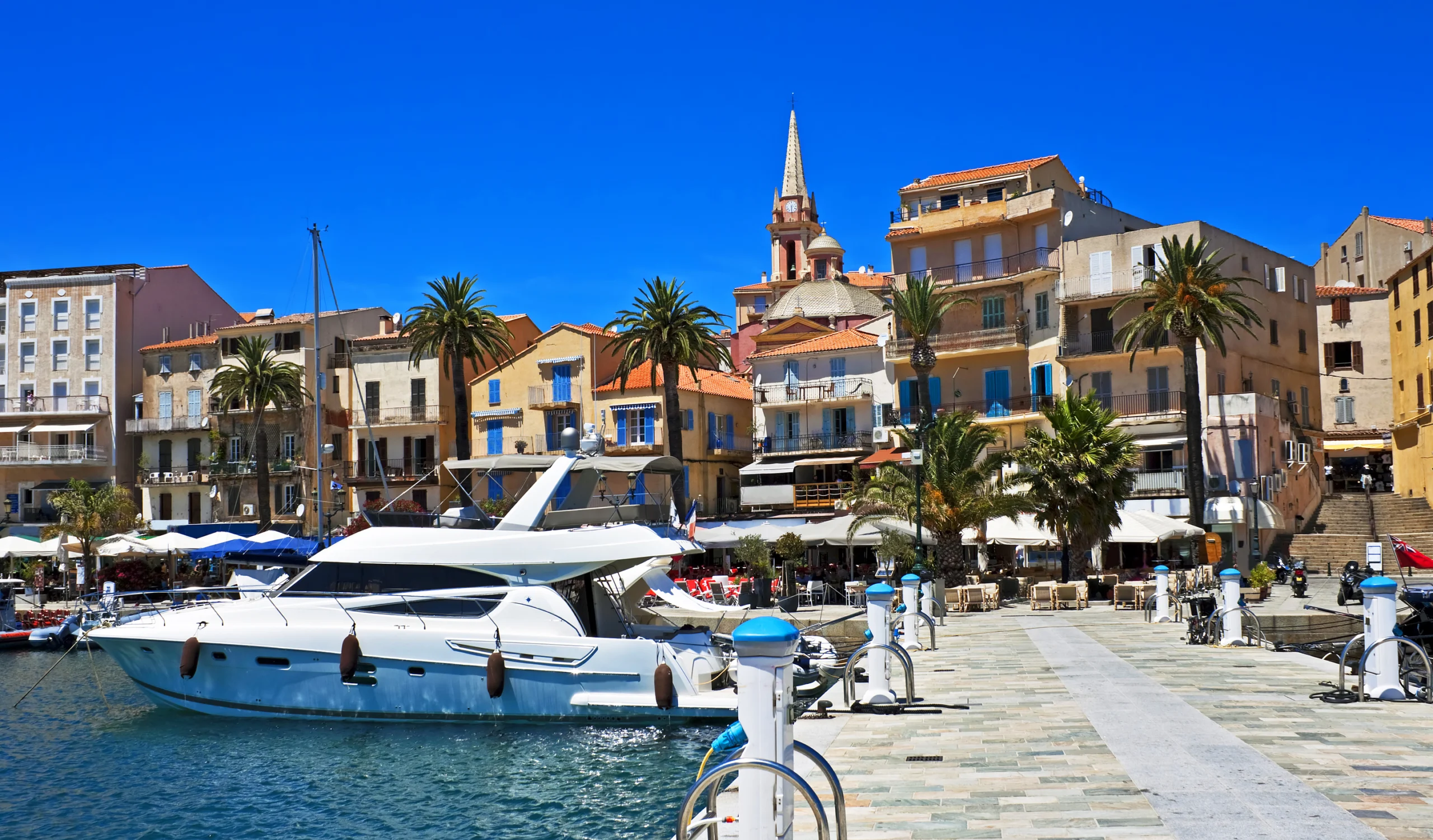 Pretty harbor with boats, cafes, and walkways, Calvi, Corsica, France.