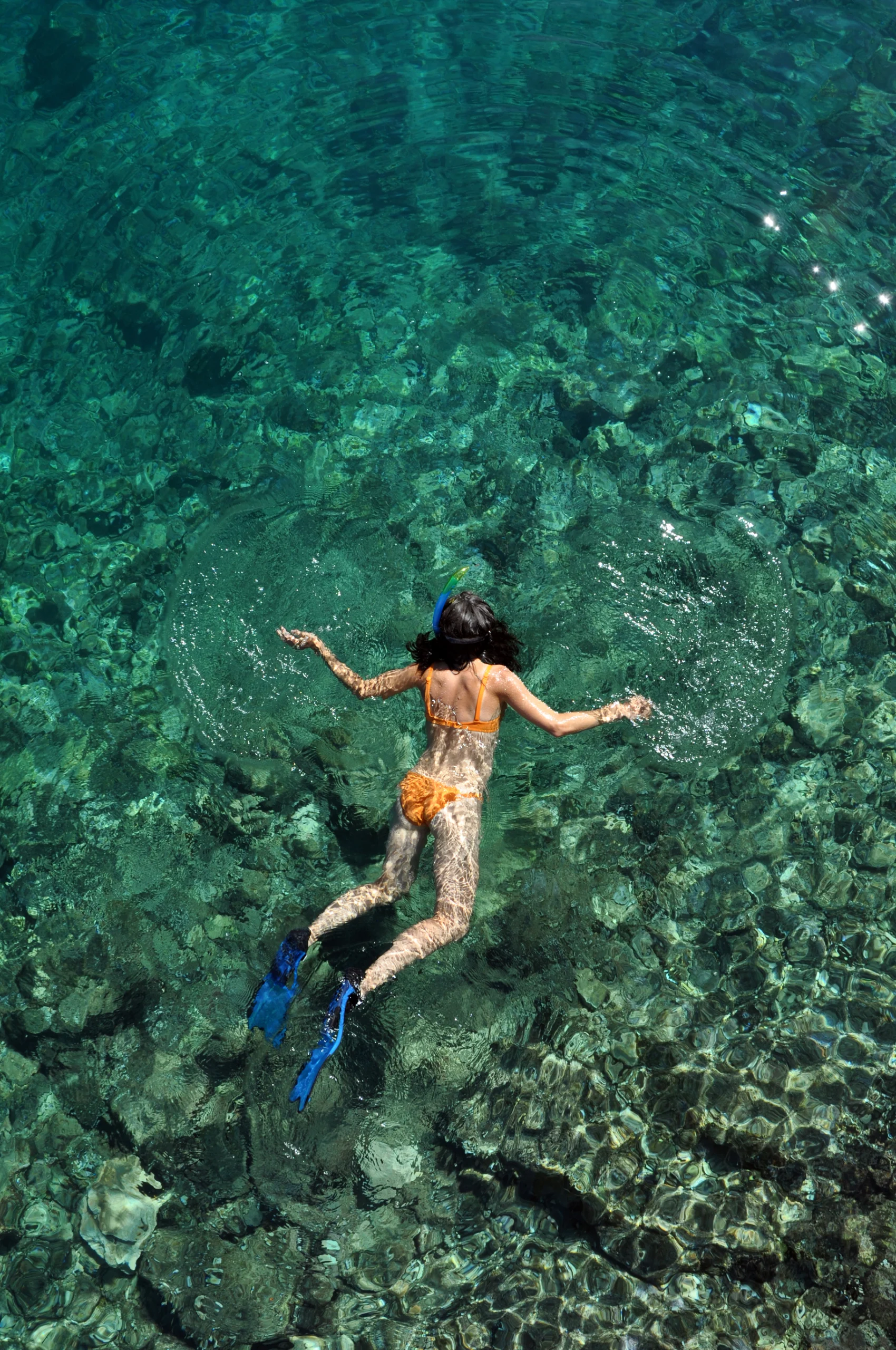 Woman snorkeling in clear sea water.