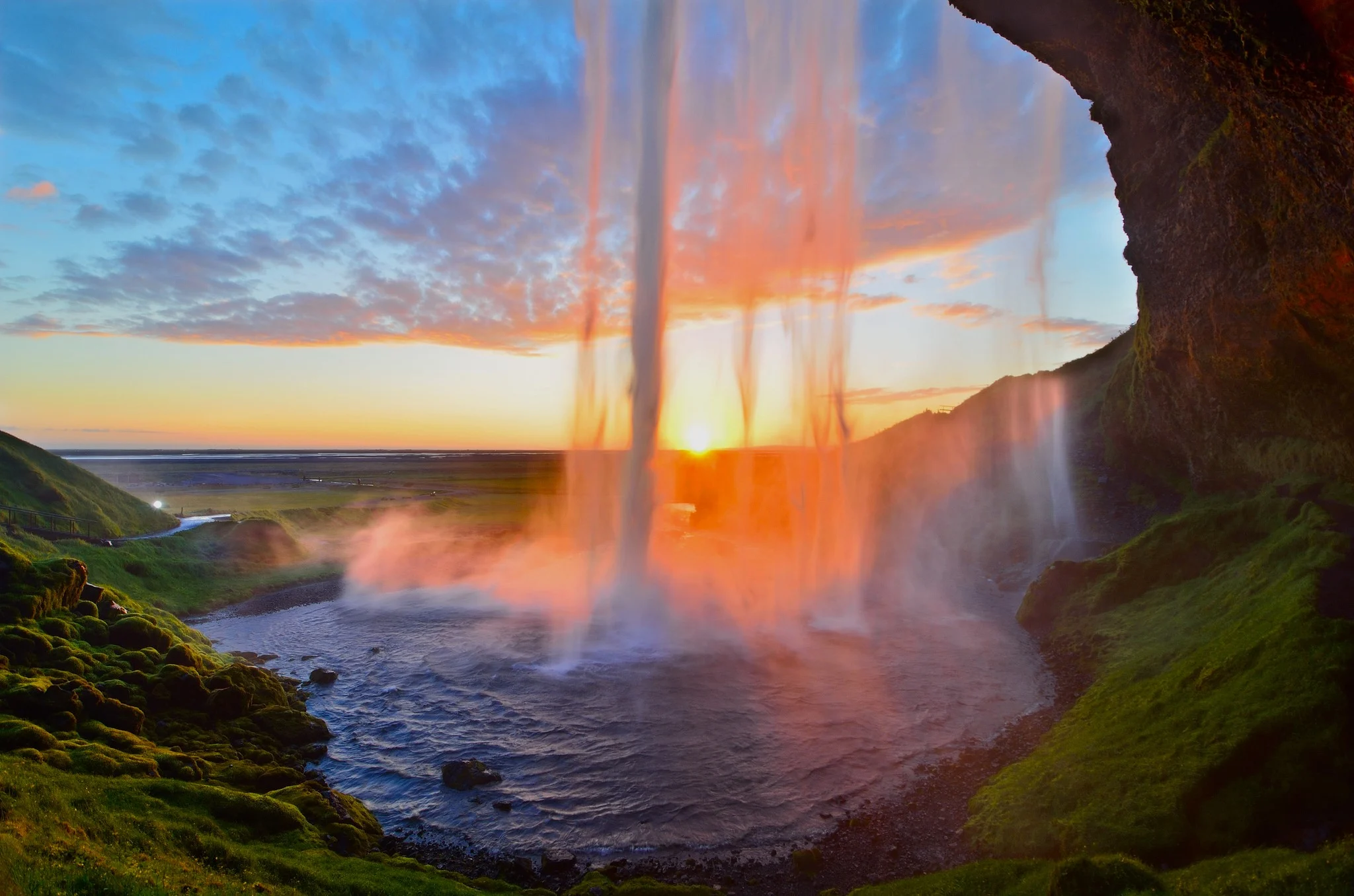 Iceland sunset from behind Seljalandsfoss waterfall.