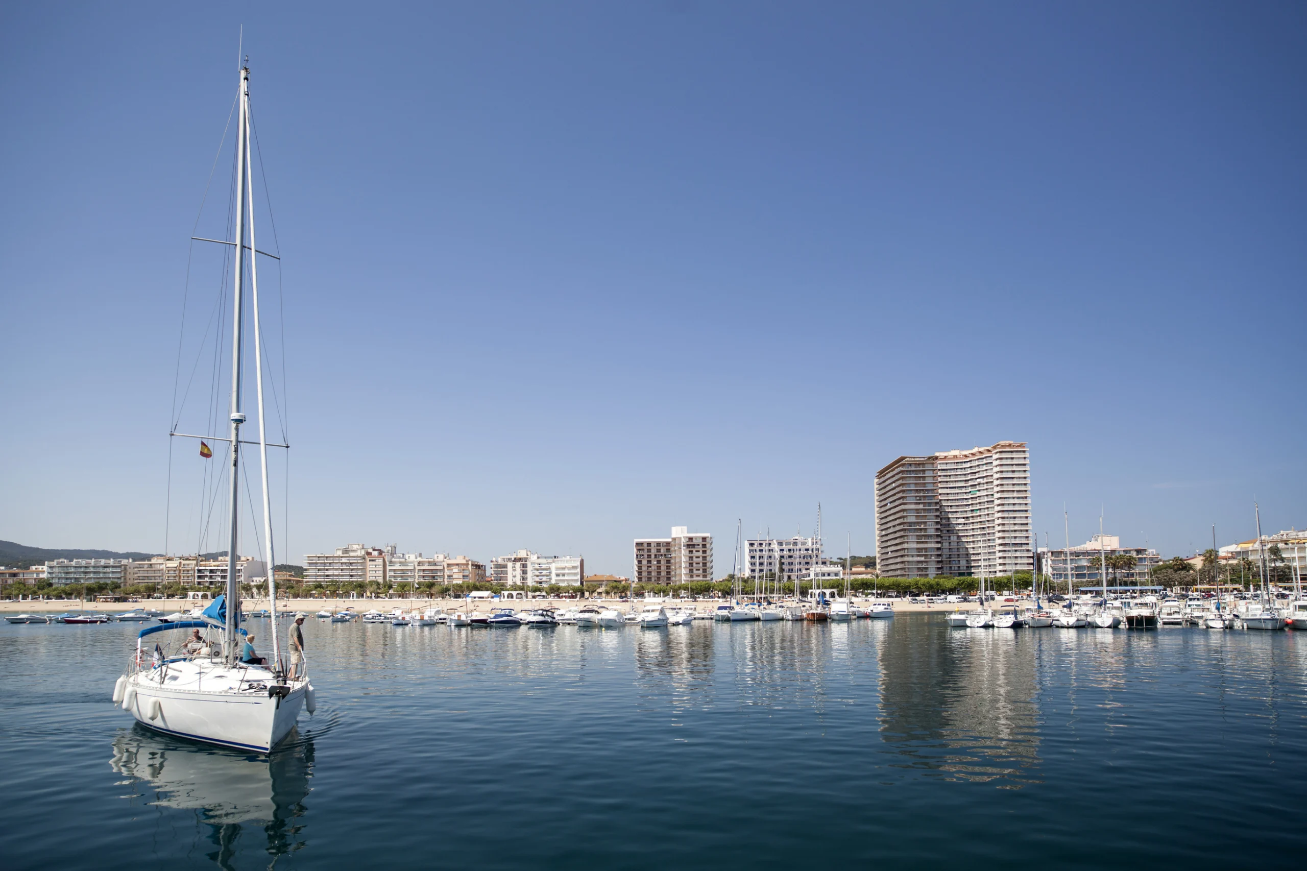 View of mediterranean town of Palamos, boat, marina, shroreline maritime residential buildings, Costa Brava, province Girona, Catalonia, Spain.