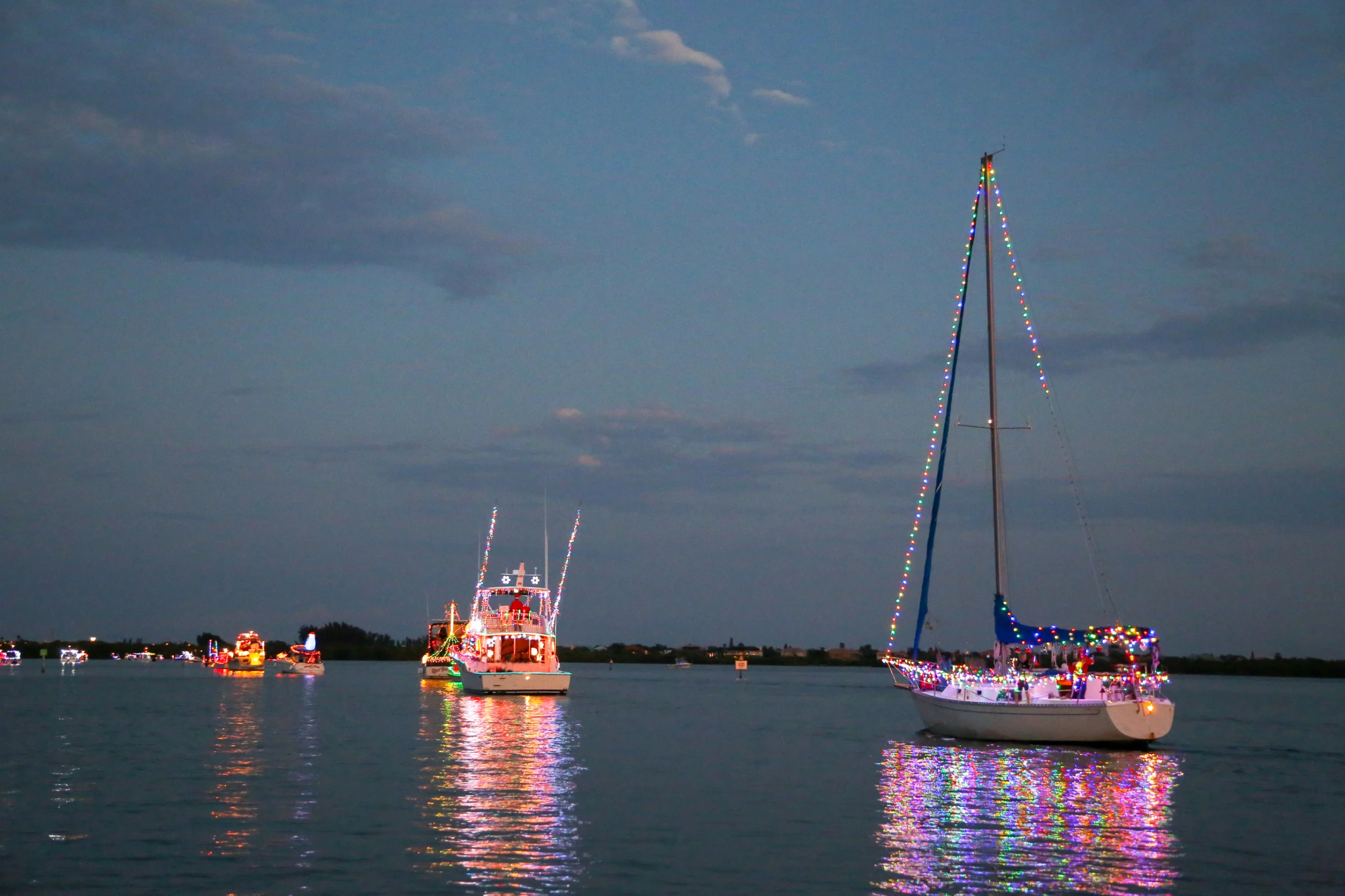 Power and Sailboats Participate in a Holiday Boat Parade