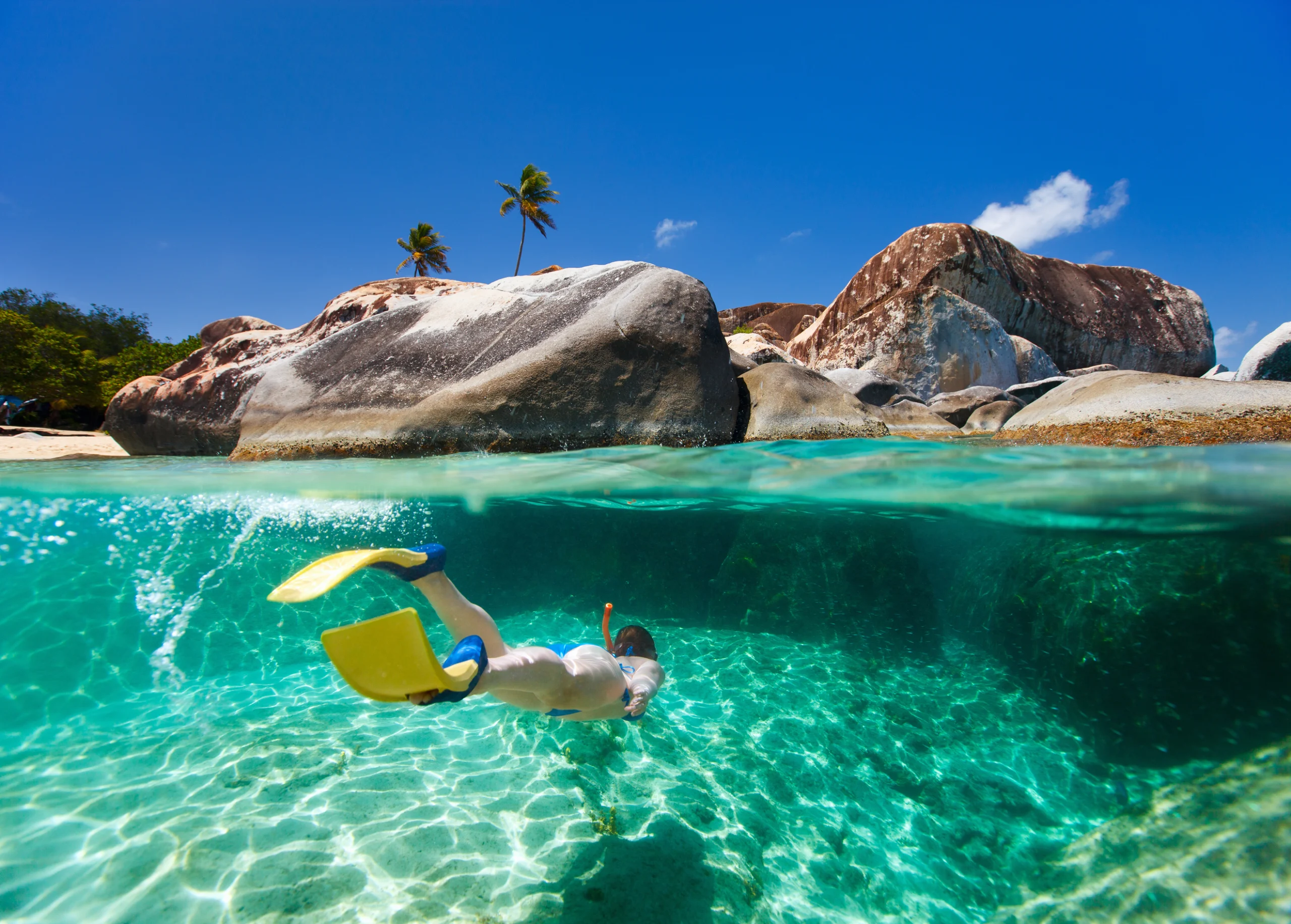 Split photo of young woman snorkeling in turquoise tropical water among huge granite boulders at The Baths beach area major tourist attraction on Virgin Gorda, British Virgin Islands, Caribbean