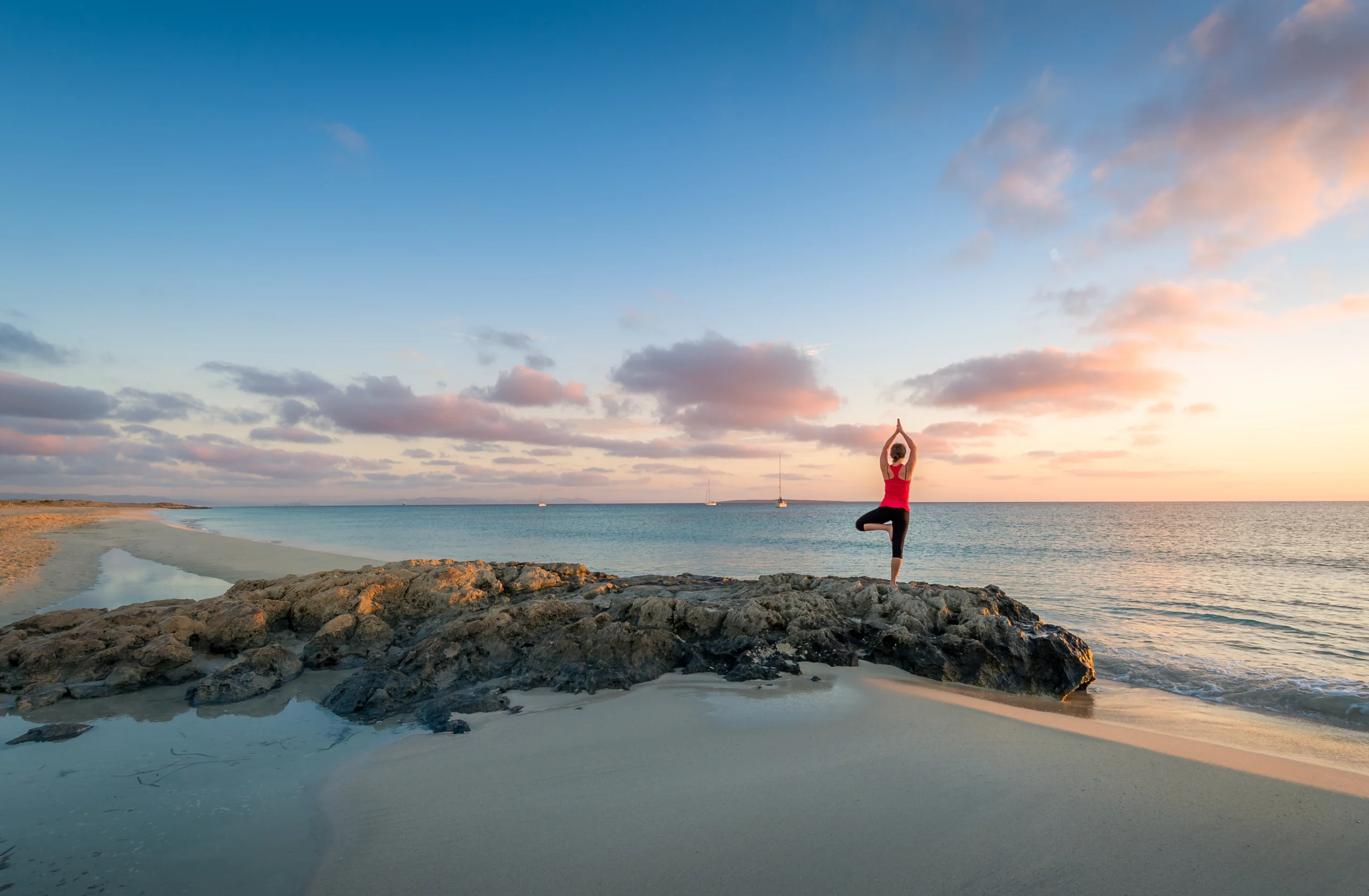 Girl doing yoga at Formentera beach