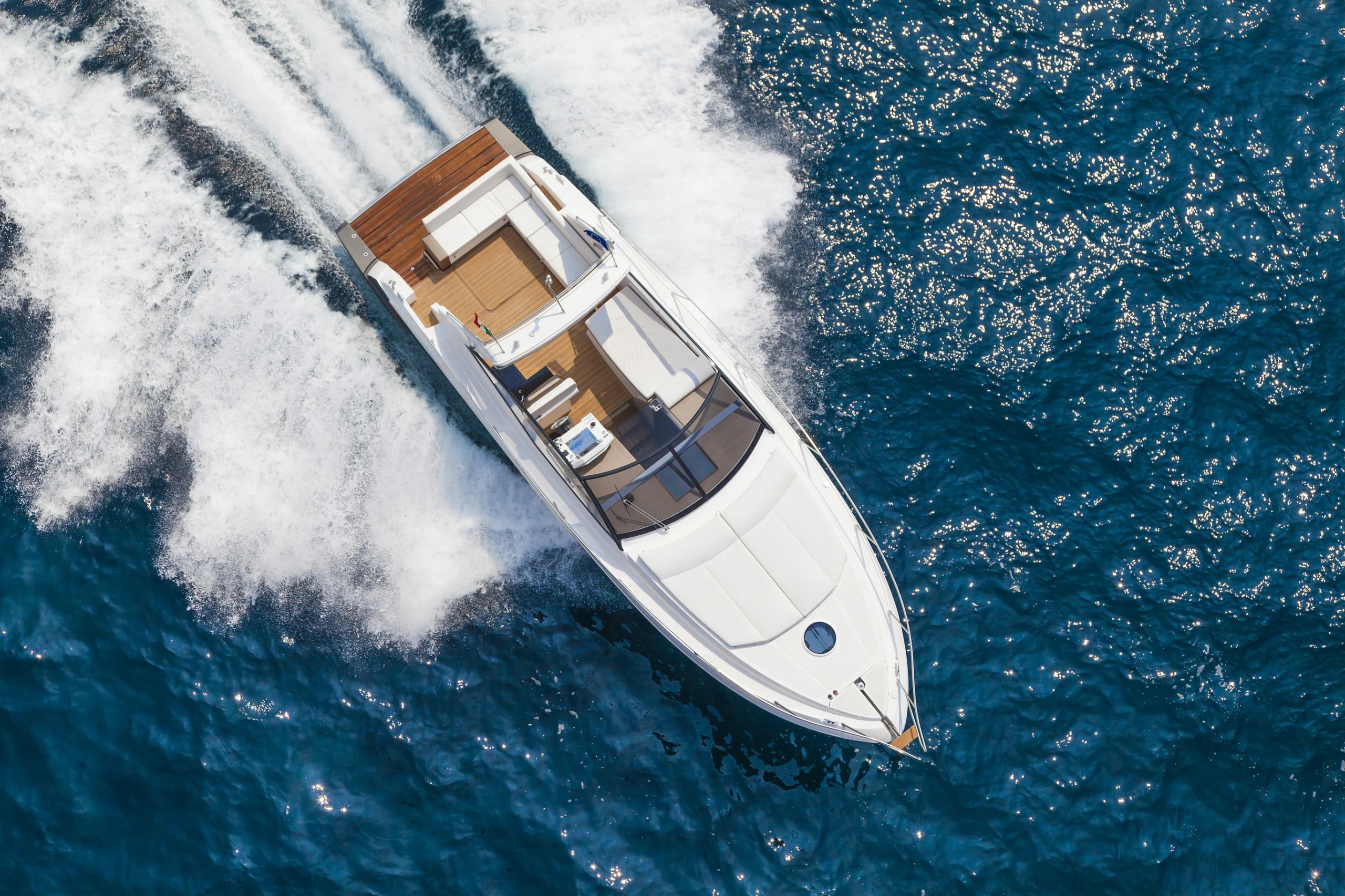 Motor yacht boat glides diagonally on the water.