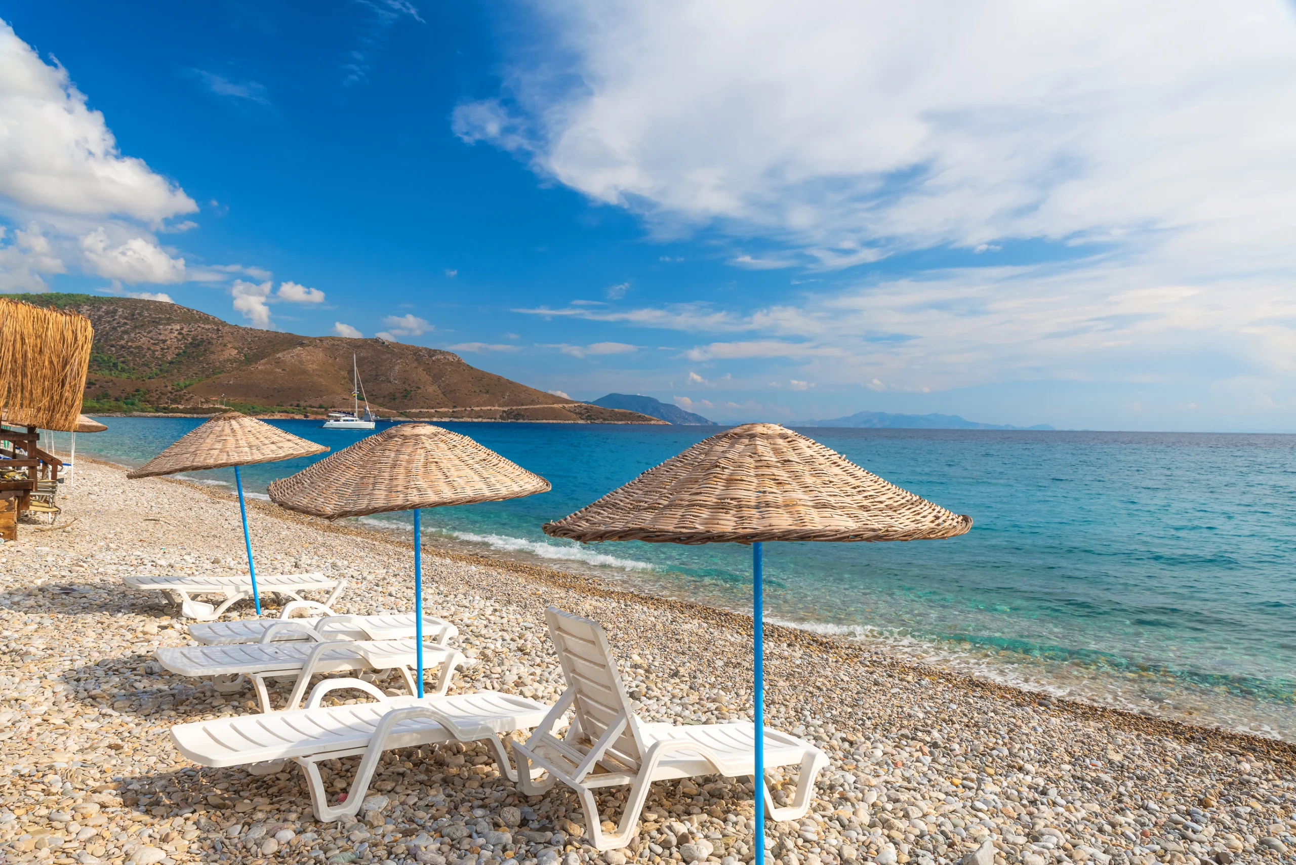 Sun loungers and umbrellas on Palamutbuku beach in Datca Peninsula, Mugla region, Turkey 