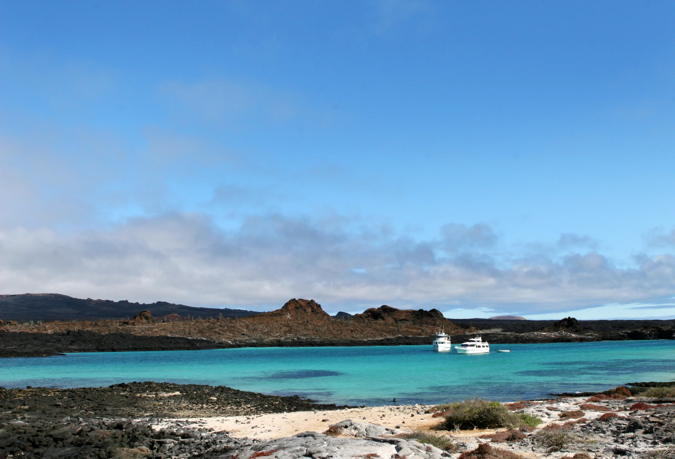 Galapagos Island Beach. Two yachts wait offshore for tourists visiting the islands