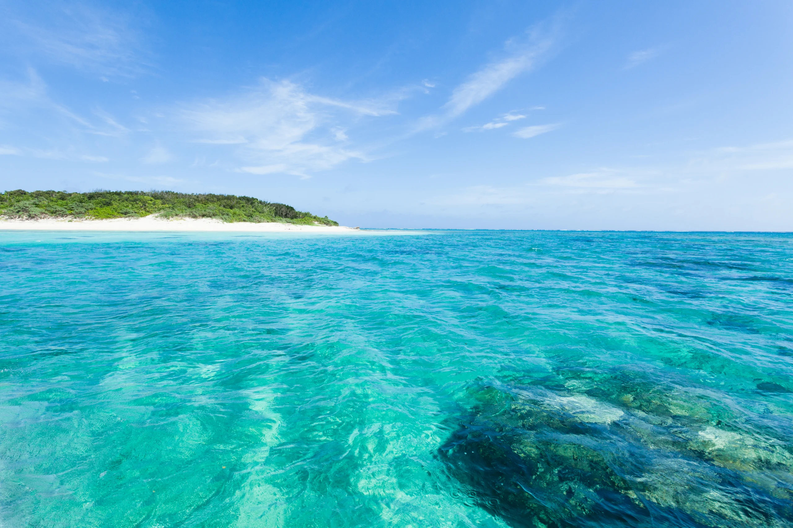 Deserted tropical island beach, clear blue water. Crystal clear blue lagoon water and deserted tropical island beach surrounded by coral reefs, Aragusuku Island of the Yaeyama Islands, Okinawa, Japan