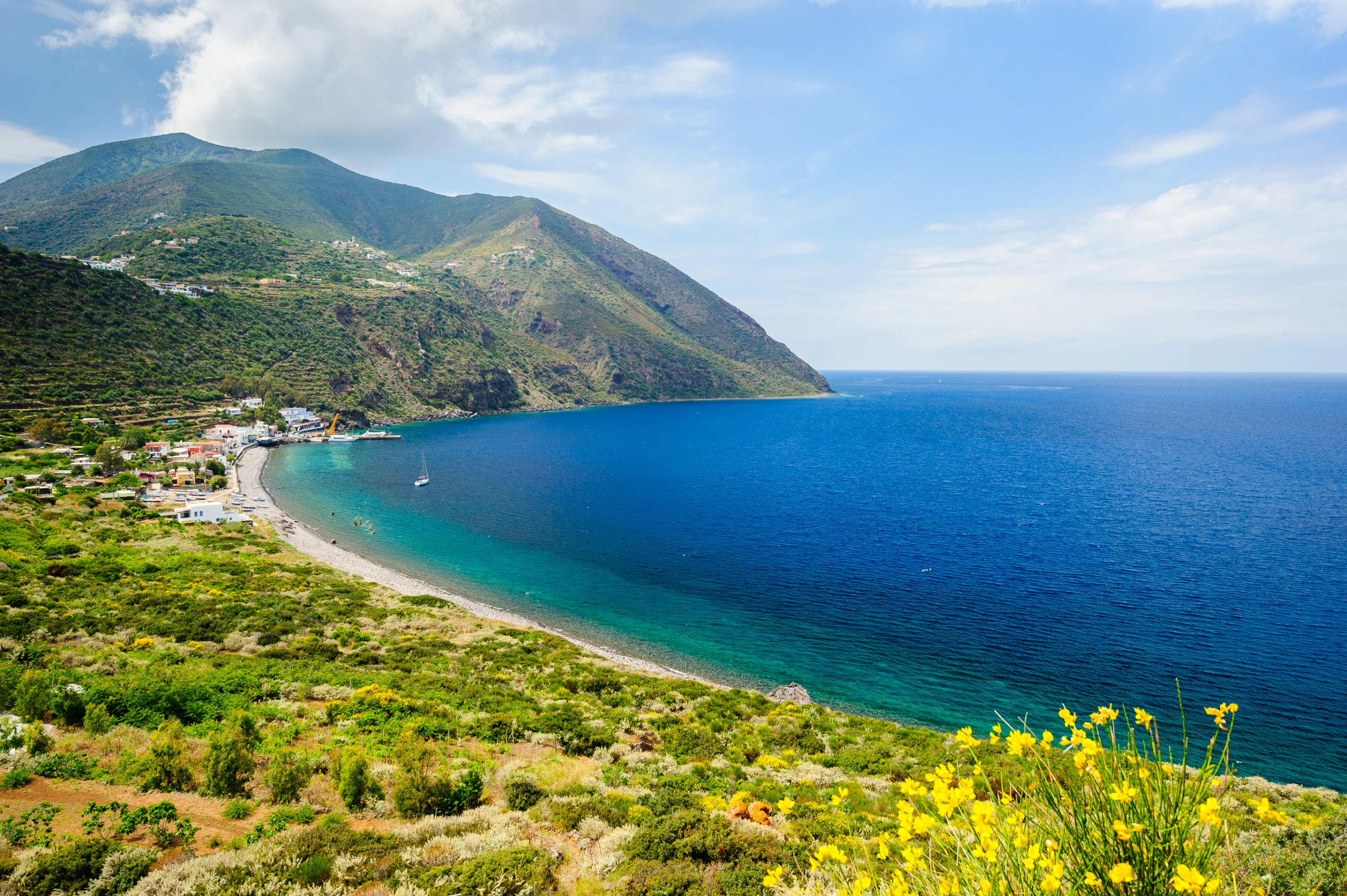 Filicudi island coastline. Filicudi island panorama with blooming flowers on the foreground, Aeolian islands, Italy.