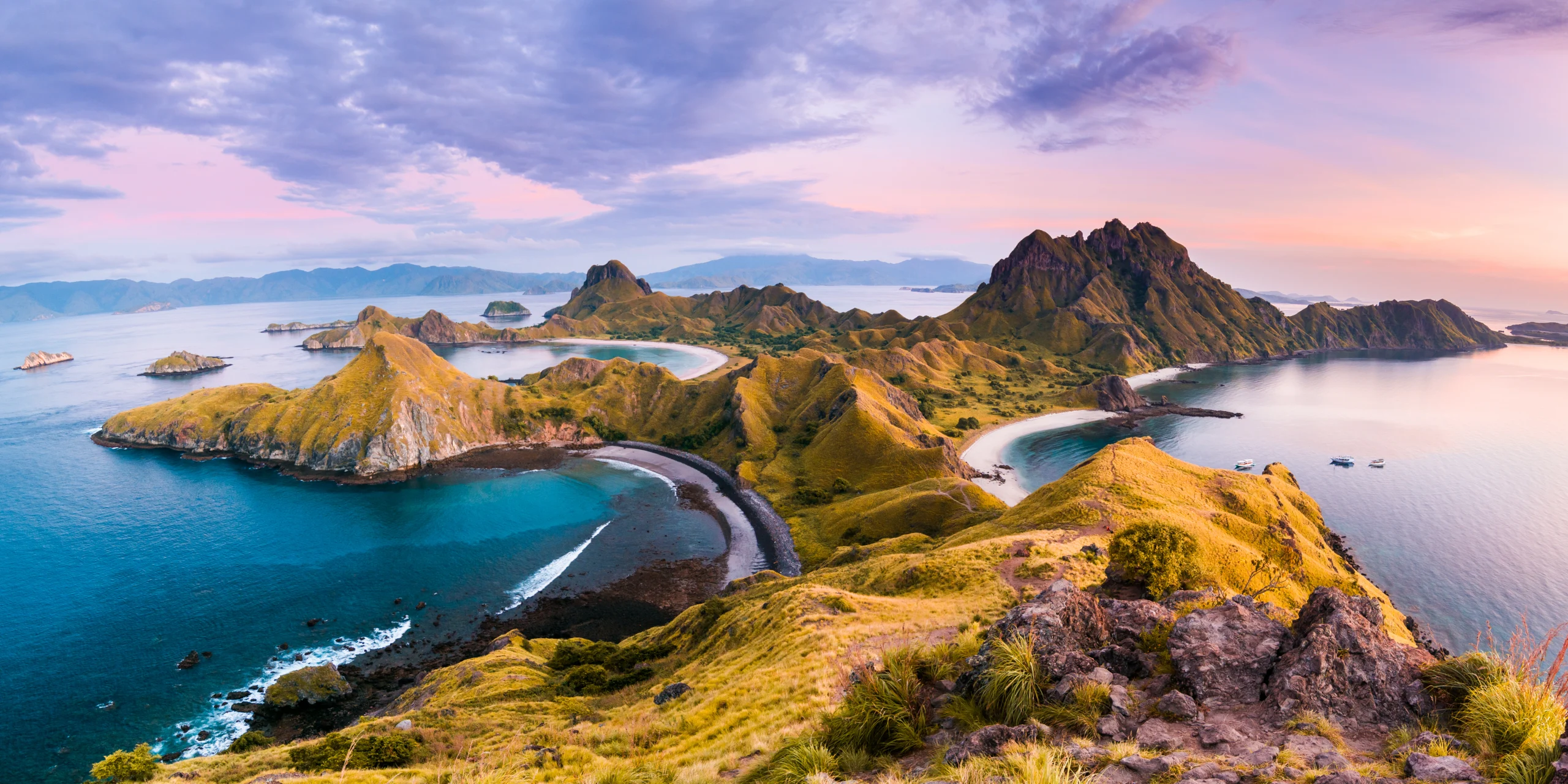 Coast view of Padar Island in a cloudy morning with blue water surface and tourist boats, Komodo Island Komodo National Park, Labuan Bajo, Flores, Indonesia