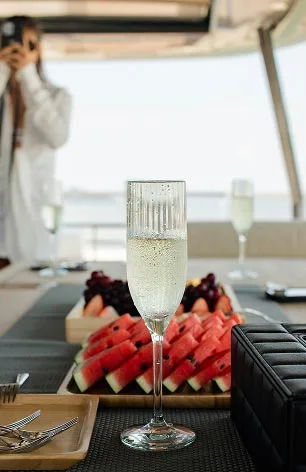 An image of a glass of champaign and a watermelon dish