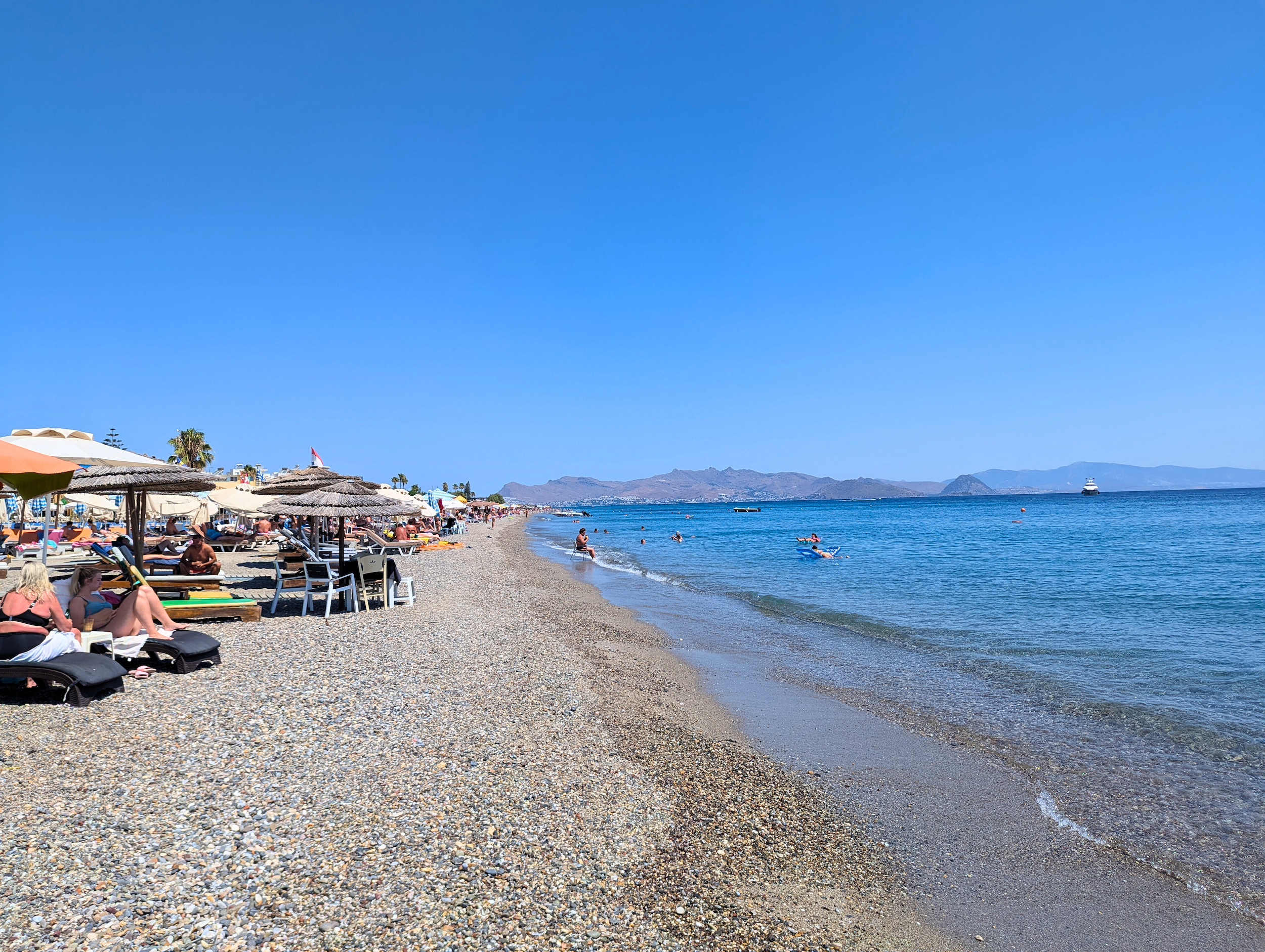 people sunbathing on the shoreline of Kos, Greece