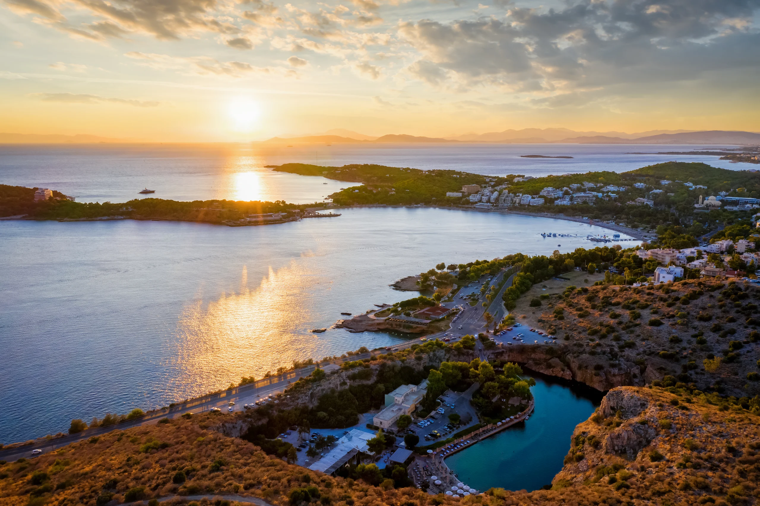 Aerial view of Lake Vouliagmeni and the coastline, south Riviera, Greece. Aerial view of Lake Vouliagmeni and the coastline with the beaches to Athens during sunset, south Riviera, Greece